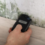 Person,Hand,Measuring,The,Wetness,Off,A,Moldy,Wall